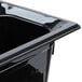 A Vollrath black plastic 1/3 size food pan on a counter.