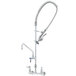 A silver T&S wall mounted pre-rinse faucet with a hose and add-on faucet.