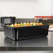 A black Vollrath plastic food pan with vegetables in it.
