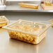 A clear plastic Vollrath high heat slotted lid on a container of food.