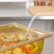 A Vollrath plastic food pan lid on a container with food.