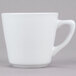 A Tuxton Alaska bright white tall coffee cup with a handle.