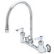 A chrome T&S wall mount faucet with two gooseneck spouts and Eterna cartridges.