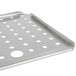 A close-up of a Vollrath stainless steel false bottom tray with holes in it.