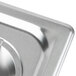 A Vollrath stainless steel cover on a metal surface.