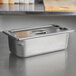 A Vollrath stainless steel pan with a lid on a counter.