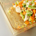 A Vollrath amber high heat drain tray filled with vegetables.