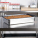 A Vollrath stainless steel steam table pan with food in it.