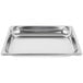 A Vollrath stainless steel 1/2 size steam table pan with holes in it on a white counter.