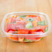 A clear Sabert plastic container filled with food.
