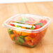 A clear Sabert square plastic container filled with cut up bell peppers.