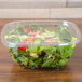 A salad in a Sabert clear plastic square bowl.