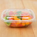 A close-up of a clear Sabert plastic container with food.