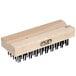 A wooden grill brush head with black bristles.