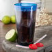 A Carlisle royal blue plastic tumbler with a straw and a lime in a drink.