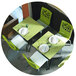 A restaurant table with white plates and Grosfillex Tempo chairs with fern green backs and white seats.
