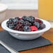 A white GET Melamine bowl filled with fruit on a table.