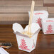 A white Fold-Pak Chinese takeout container with chopsticks inside.