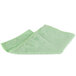 A folded green Unger SmartColor microfiber cleaning cloth on a white background.