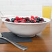 A white bowl filled with berries on a table.