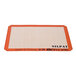 A close-up of a white SILPAT baking mat with orange lettering.
