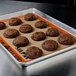 A SILPAT baking mat on a tray of chocolate cookies on a counter.