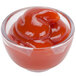 A clear Carlisle plastic sauce cup filled with red sauce.