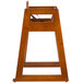 A wooden high chair stand with a strap.