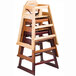 A stack of unassembled Tablecraft hardwood high chairs.