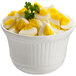 A Tablecraft white cast aluminum bowl filled with hard boiled eggs.