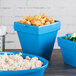 A table with blue Tablecraft square condiment bowls filled with salad toppings.