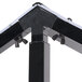 A black metal Carlisle adjustable double sneeze guard on a table with silver screws.