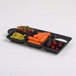 An Elite Global Solutions black melamine tray with different vegetables and fruits in it.