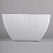 A white Carlisle melamine serving bowl with a curved edge.