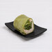 A green wrap with chicken and lettuce on a black Elite Global Solutions Ore plate.