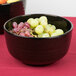 A Tablecraft black cast aluminum fruit bowl with green speckles filled with grapes.