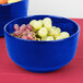 A Tablecraft cobalt blue cast aluminum fruit bowl filled with grapes on a table.