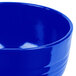 A close up of a cobalt blue Tablecraft cast aluminum fruit bowl.