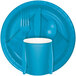 A turquoise blue paper plate with a fork, spoon and knife.