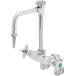 A silver T&S chrome wall mount mixing faucet with 4 green arm handles.