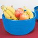 A Tablecraft sky blue cast aluminum bowl filled with apples and bananas on a table.