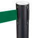 A black Aarco crowd control stanchion with dual green retractable belts.