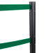 A black Aarco crowd control stanchion with green tape and a white stripe.