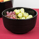 A Tablecraft black and blue speckled ceramic fruit bowl filled with grapes.