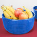 A Tablecraft blue speckle cast aluminum fruit bowl filled with bananas and apples on a table.