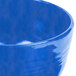A close up of a blue Tablecraft cast aluminum fruit bowl.
