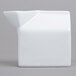An American Metalcraft white ceramic milk carton creamer on a gray surface.