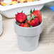 A Tablecraft natural aluminum round condiment bowl filled with strawberries on a table.