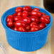 A blue Tablecraft cast aluminum souffle bowl filled with cherry tomatoes.