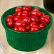 A green Tablecraft cast aluminum bowl filled with cherry tomatoes.
